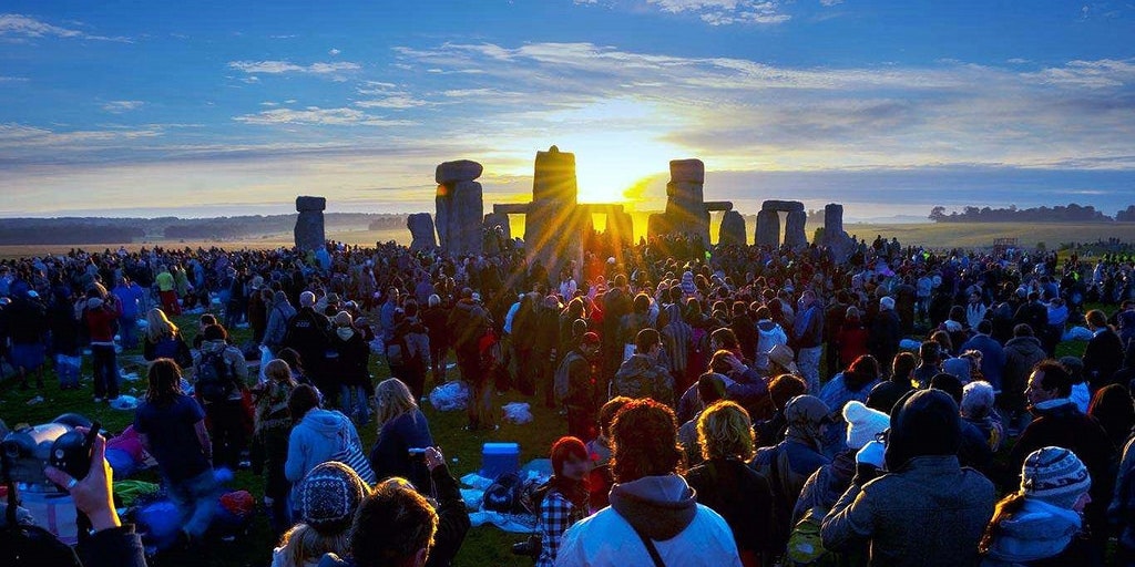 Les fêtards regardent le Solstice Sun s'élever sur Stonehenge Heel Stone
